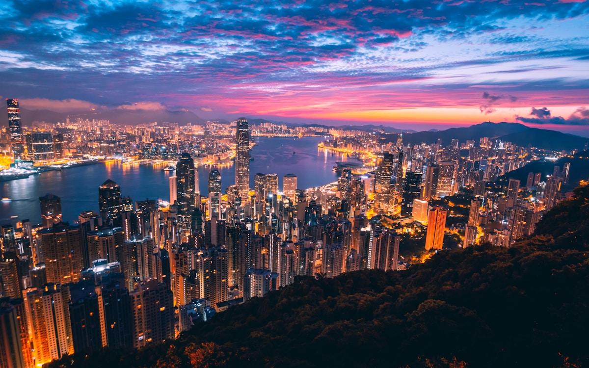Hong Kong skyline at dusk with illuminated skyscrapers along Victoria Harbour